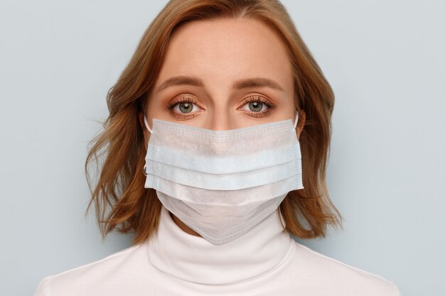 여자 얼굴 의료 마스크를 쓰고 찾고 있습니다. 독감 전염병, 먼지 알레르기, 바이러스 예방. Covid-19, 코로나 바이러스.