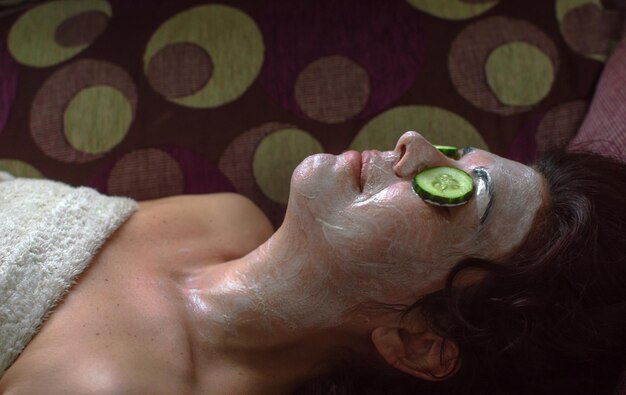 Photo woman wearing facial mask lying in spa