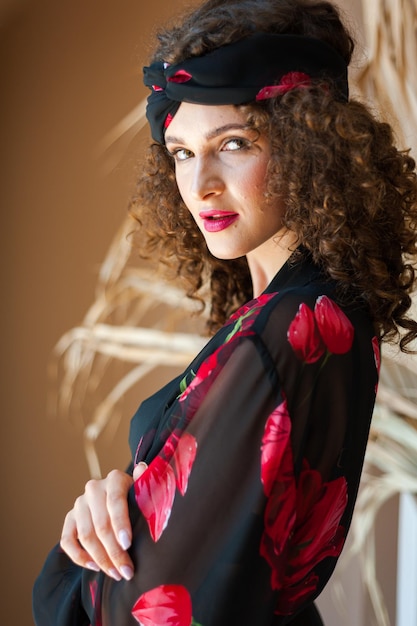 A woman wearing a flowered dress and a hat