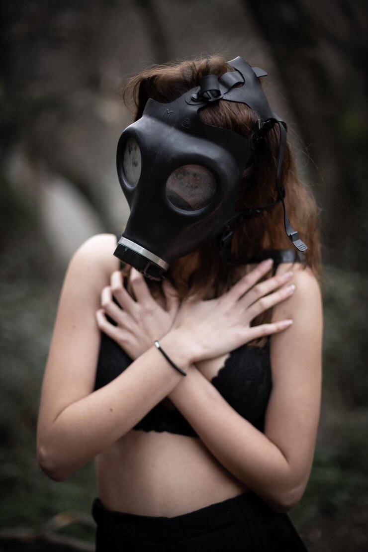 Photo woman wearing gas mask while covering chest