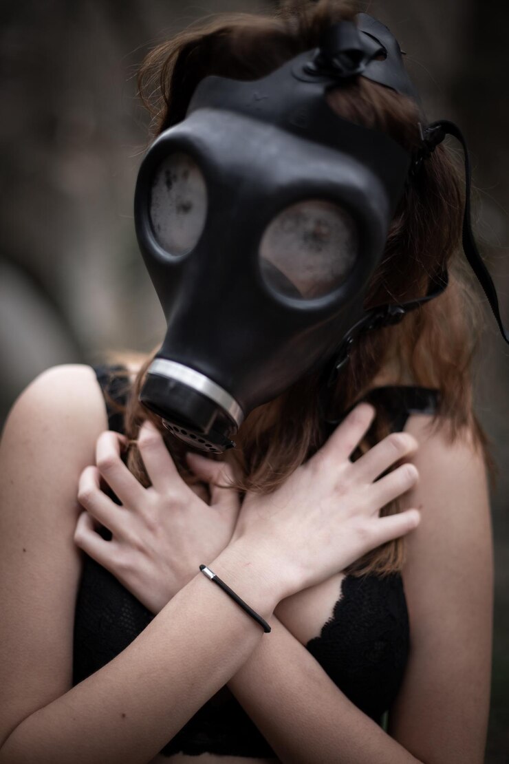 Photo woman wearing gas mask while covering chest