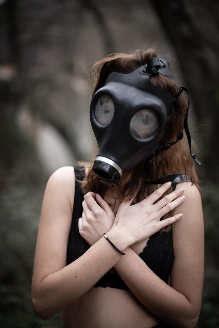 Photo woman wearing gas mask while covering chest