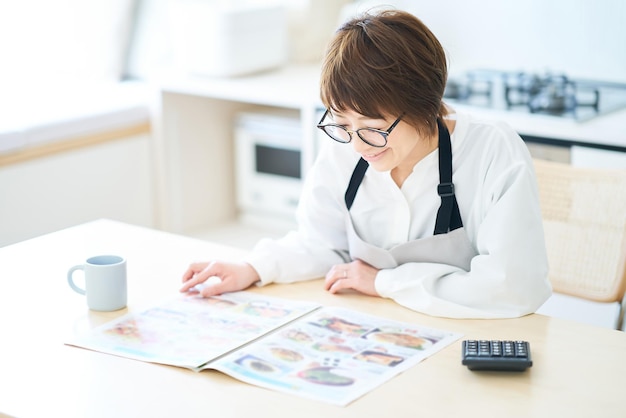 A woman wearing glasses looking at an advertising leaflet