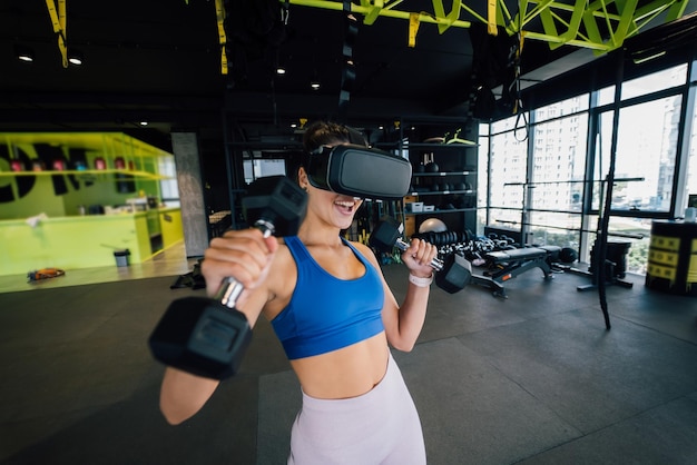 Woman wearing glasses of the virtual reality exercising with\
dumbbells