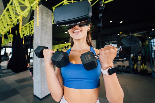 Женщина в очках виртуальной реальности тренируется с гантелями