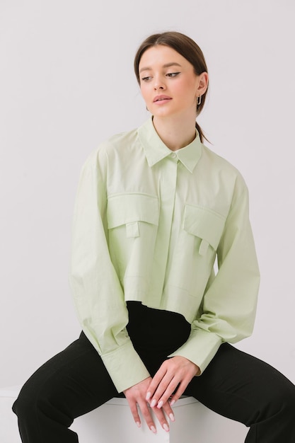 A woman wearing a green shirt from the brand new spring collection.