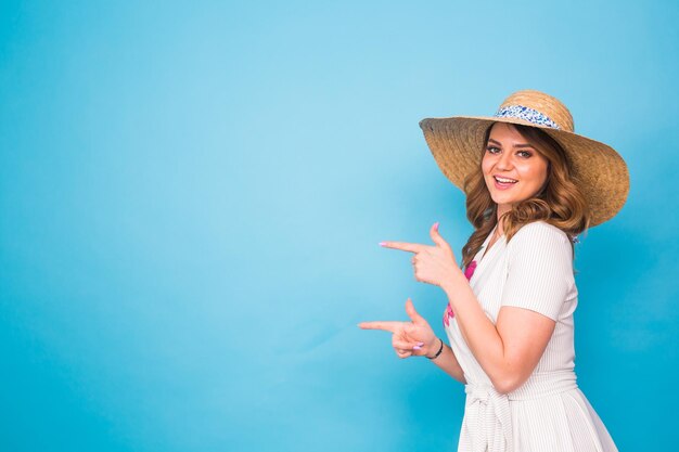 Woman wearing hat standing against blue sky