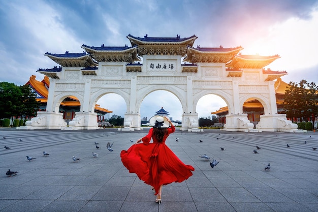 Woman wearing hat standing against building