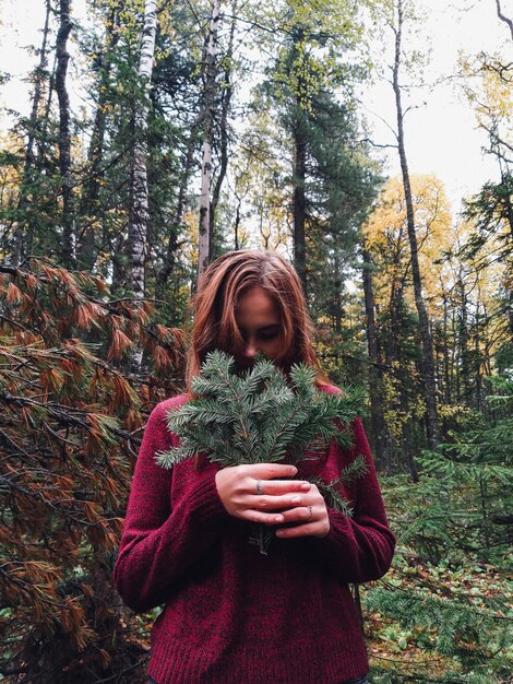 Foto donna con il cappello in piedi nella foresta