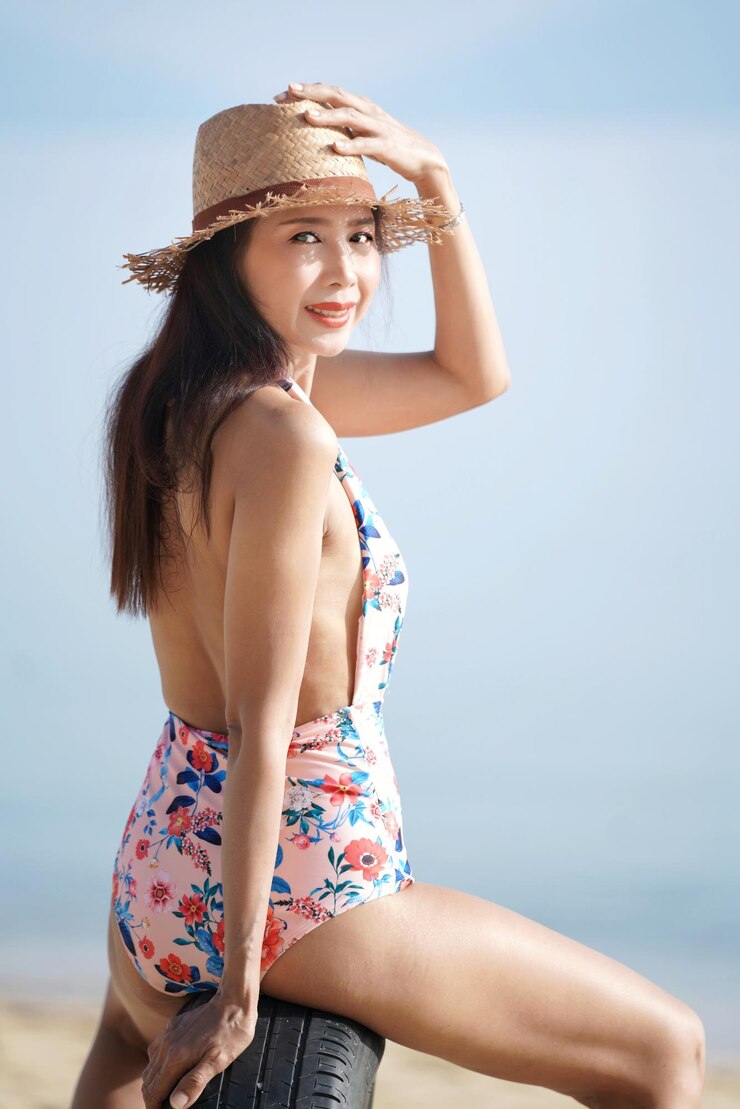 Photo ビーチのタイヤに帽子をかぶった女性