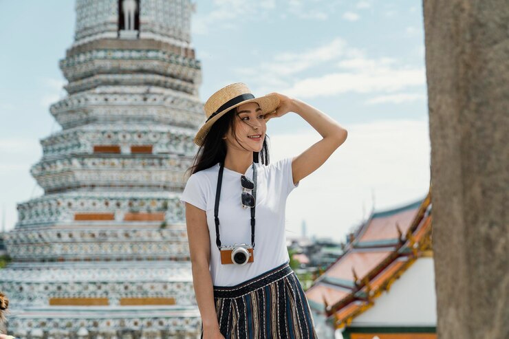 Photo 建物に向かって立っている女性が帽子をかぶっている
