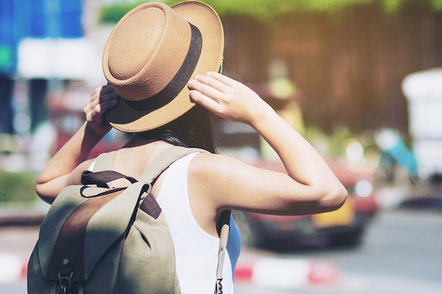 Woman wearing hat while standing in city