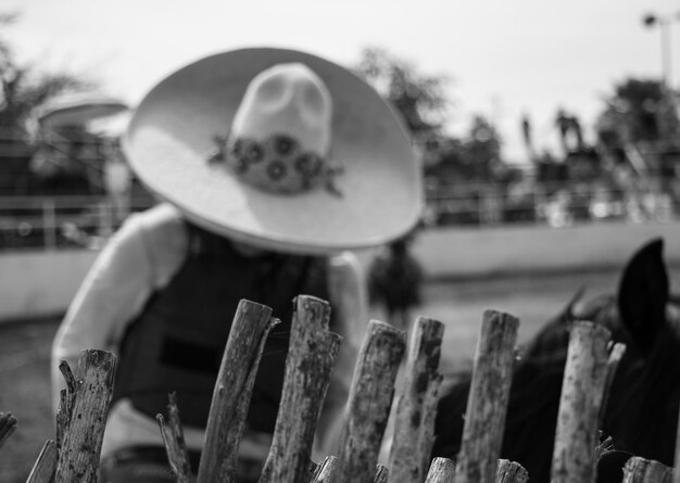 Photo woman wearing hat working by fence