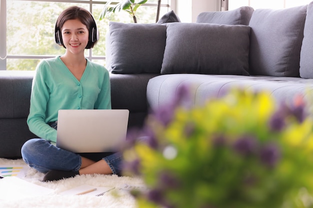 Photo woman wearing headphone holding computer.