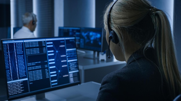 a woman wearing a headset sits at a computer with a screen that says call of duty.