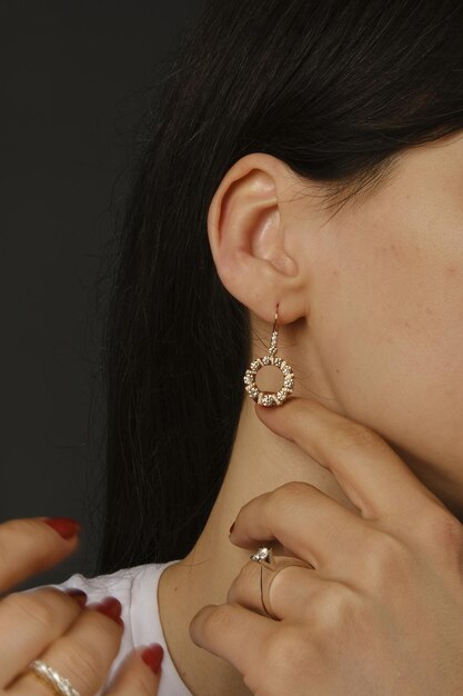 Photo a woman wearing a heart shaped earring is wearing a heart shaped necklace