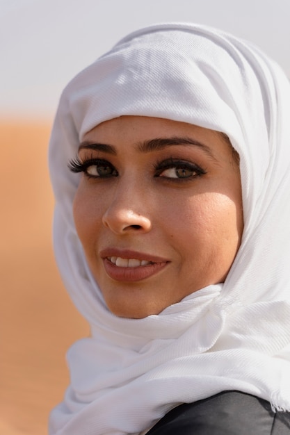 写真 砂漠でヒジャーブを着ている女性