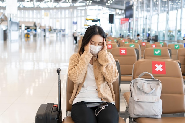 사진 공항 라운지 에 앉아 있는 마스크 를 착용 한 여자