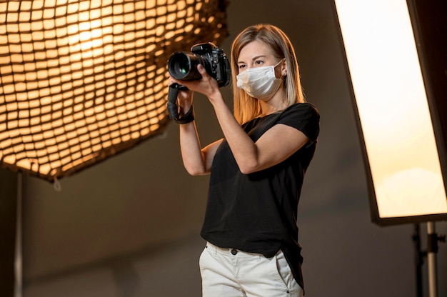 Woman wearing medical mask and taking photos