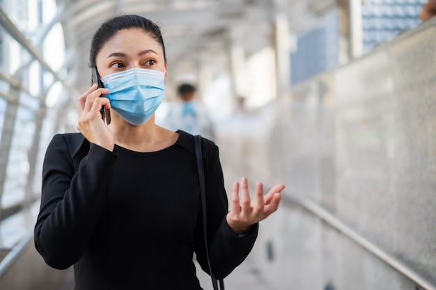 Photo woman wearing medical mask and talking on mobile