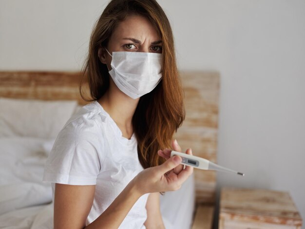 Photo woman wearing medical mask thermometer health check dissatisfied facial expression