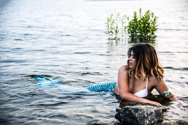 写真 海で休むとき人魚の衣装を着た女性