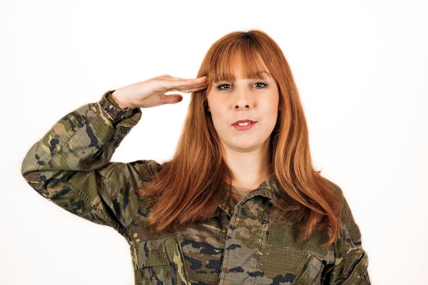 Woman wearing military camouflage giving a military hand salute with a smile