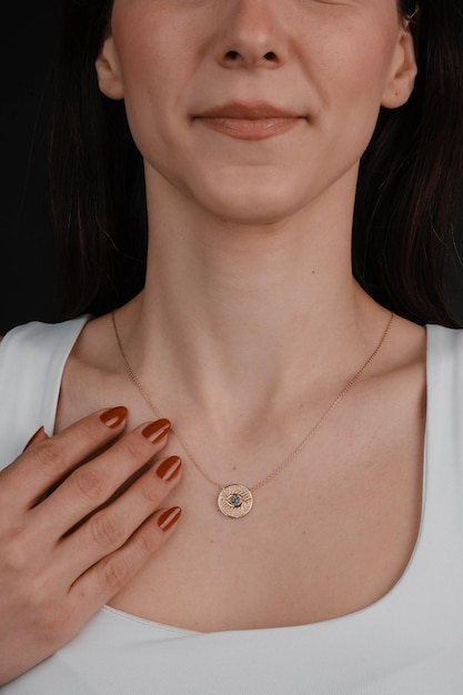 a woman wearing a necklace with a diamond on it