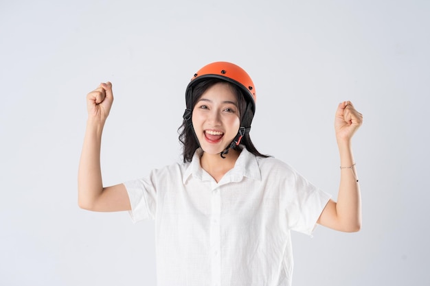 Woman wearing orange helmet on white background