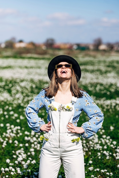 Woman wearing overalls with yellow and white flowers in pockets