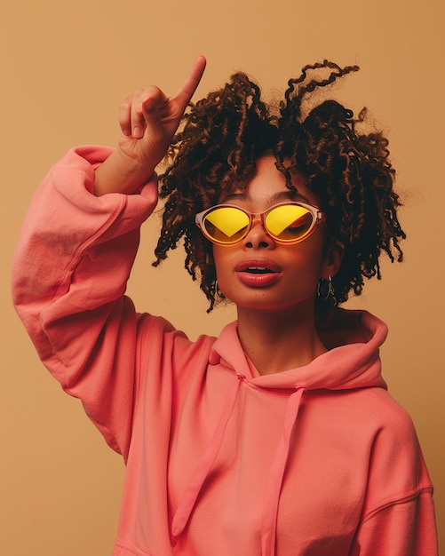 a woman wearing a pink hoodie with her hand up in the air