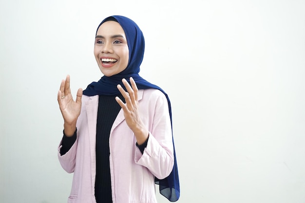 A woman wearing a pink jacket and a pink jacket is speaking and smiling.