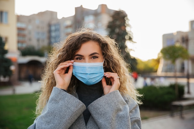 Photo woman wearing protective mask against coronavirus. coronavirus covid-19 pandemic and healthcare concept. coronavirus precautions