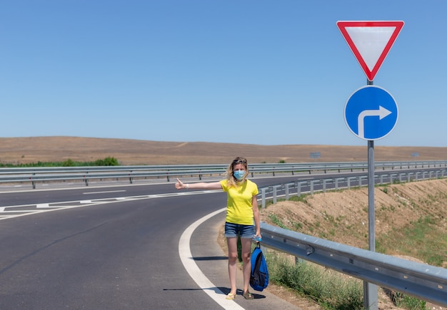 道路上の防護マスクを着ている女性