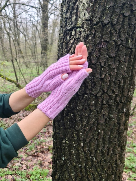 Photo a woman wearing purple gloves next to a tree