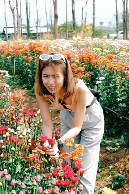 写真 赤い花の植物を着た女性