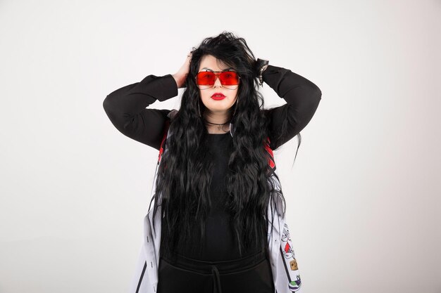 Woman wearing red glasses on white background