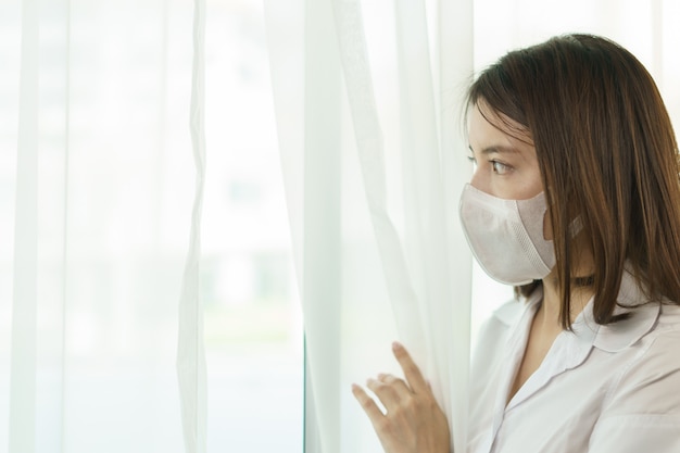 Donna che indossa occhiali protettivi e maschera, per evitare la diffusione del coronavirus.