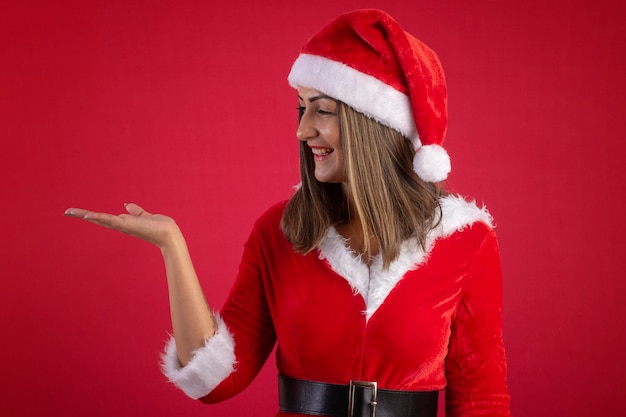 Woman wearing a santa claus dress and hat on a red background with a christmas theme