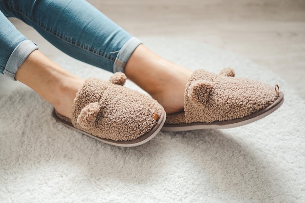 Woman wearing soft comfortable slippers at home closeup