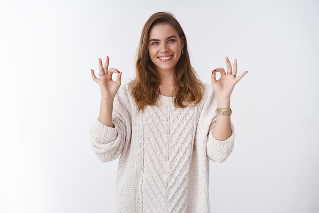 woman wearing stylish loose cozy sweater showing okay ok excellent gesture smiling positive approval agree