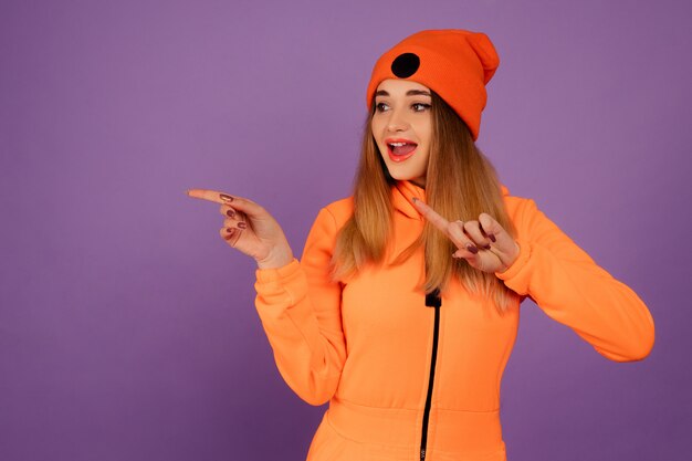 Woman wearing a  stylish orange overall on violet background