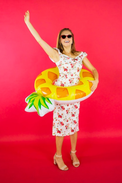 Woman wearing summer dress and yellow inflatable