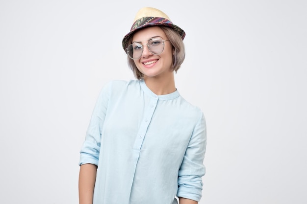 Woman wearing summer hat being very glad smiling with broad smile showing her perfect teeth