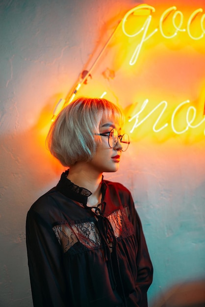 戴著太陽眼鏡的女人站在牆旁望遠