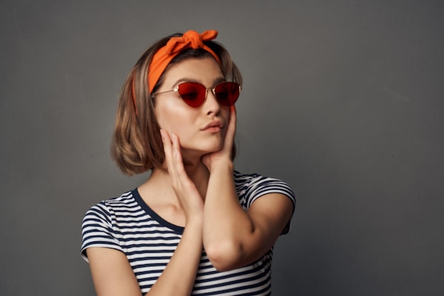 頭の孤立した背景ファッションにオレンジ色の包帯でサングラスをかけている女性