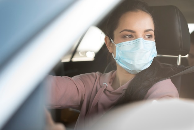 Photo woman wearing surgeon mask in car