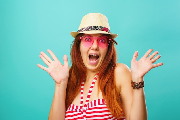 Woman wearing a swimsuit and hat smiling