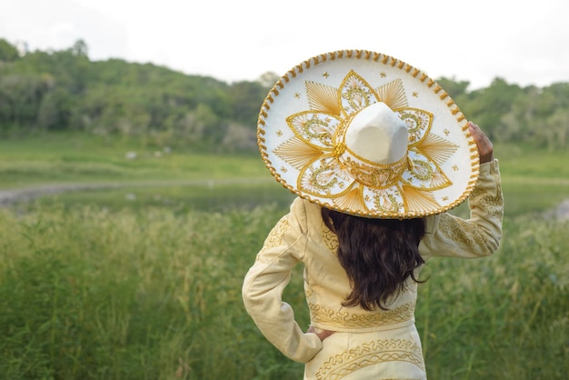 Woman wearing typical Mexican charro costume Woman with Mexican hat seen from behind