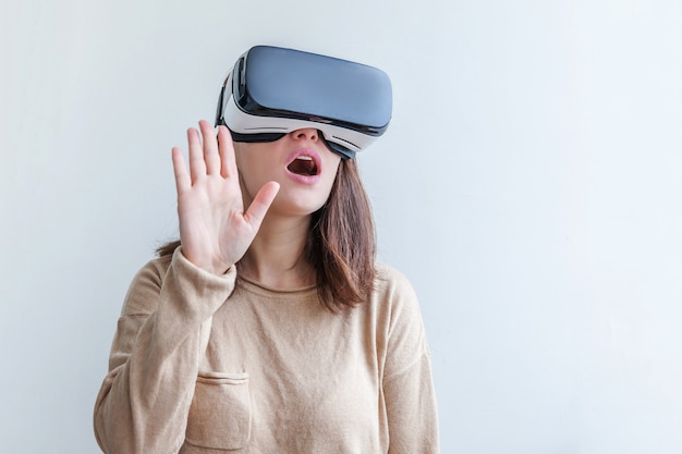 Woman wearing using virtual reality VR glasses helmet headset